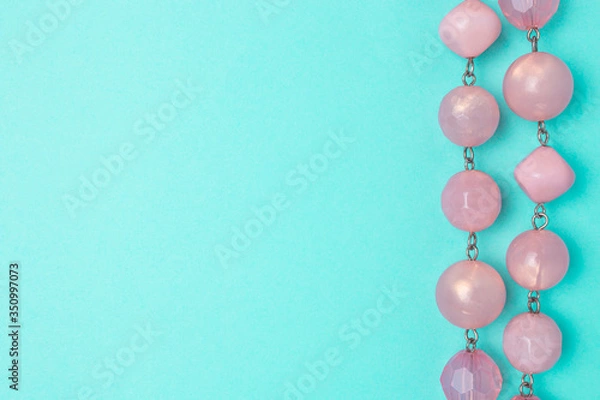 Obraz Purple beads on a blue background with copyspace.