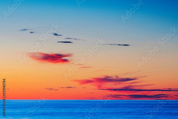 Obraz Vibrant colored summer sunset reflecting in ocean with endless horizon and deep blue ocean at island of Gotland in Sweden