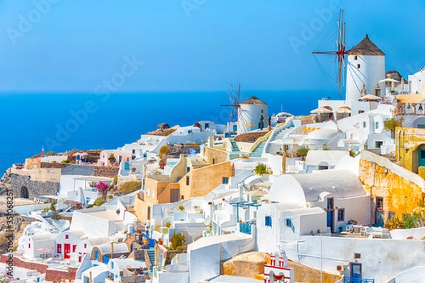 Fototapeta Greece Traveling. View of Greek Traditional Colorful Houses and Windmills of Oia or Ia at Santorini Island in Greece at Daytime.