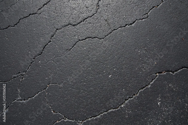Fototapeta cracked black asphalt texture, pattern, background. Flat lay. Top view.