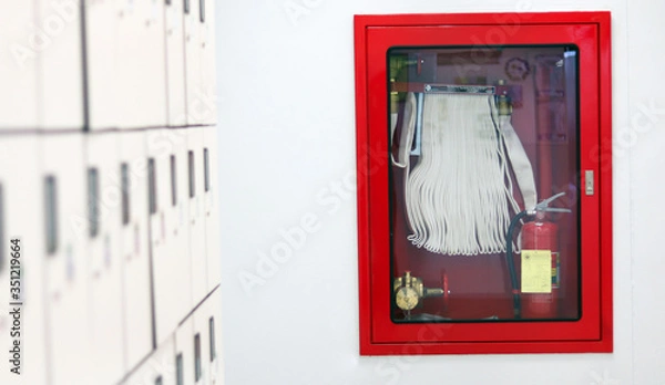 Fototapeta Red Fire extinguisher and fire hose reel setting in laboratory walkway industrial control system with fire alarm controller, for evacuation escape plan response for emergency situation in industry.