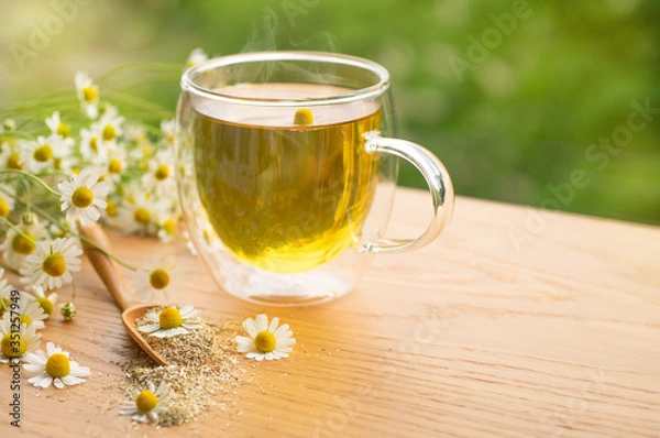 Fototapeta Chamomile flowers and chamomile tea. Herbal chamomile tea. Close-up.