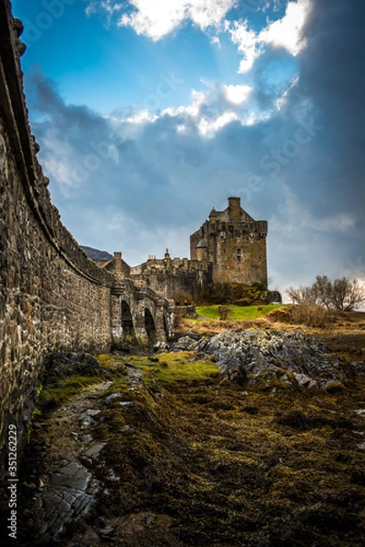Fototapeta panoramic view on Eileen Donan Castle with a moody cloudy sky 