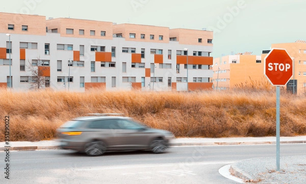Fototapeta Panning with city in the background, with dry field and clear sky and STOP signal