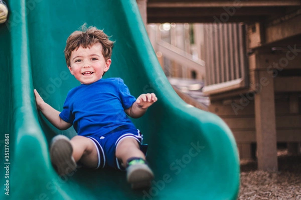 Fototapeta boy on playground slide in marco island mackle park 