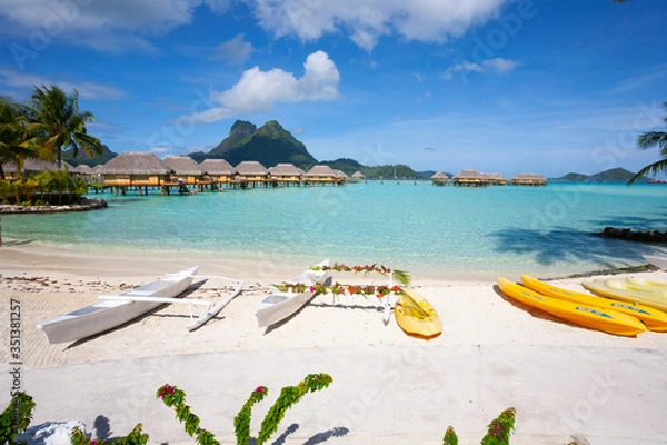 Fototapeta Bora Bora lagoon with overwater huts and outrigger boats
