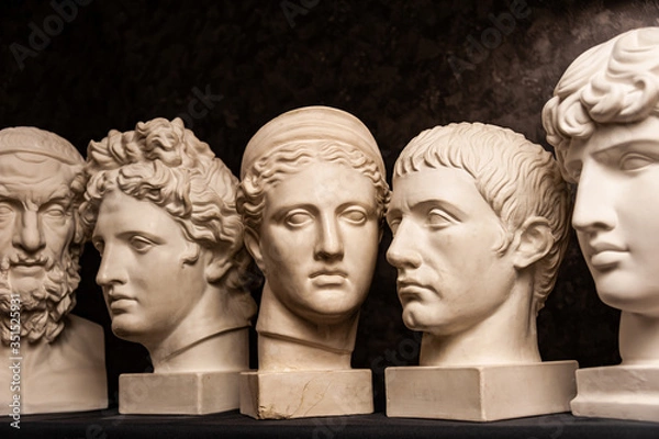 Obraz Group gypsum busts of ancient statues human heads for artists on a dark background. Plaster sculptures of antique people faces. Renaissance epoch style. Academic subject. Blank for creativity.
