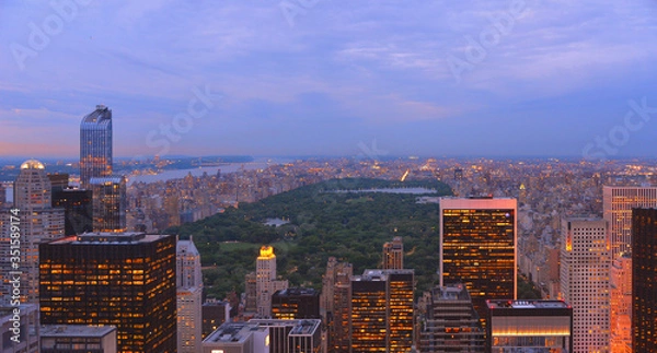 Fototapeta Aerial view on Manhattan roofs, central park and horizon with blue cloudy sky in Manhattan, New York