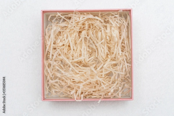 Obraz Opened box with decorative straw or shavings, top view, copy space