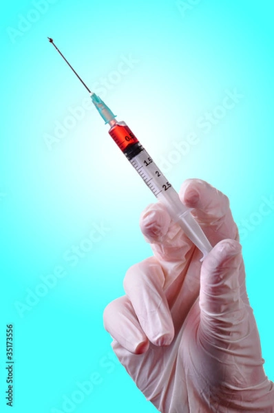 Fototapeta Hand holding a syringe