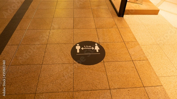 Fototapeta A social distance warning sign on the ground in a shopping mall.The mark was placed because of the coronavirus.