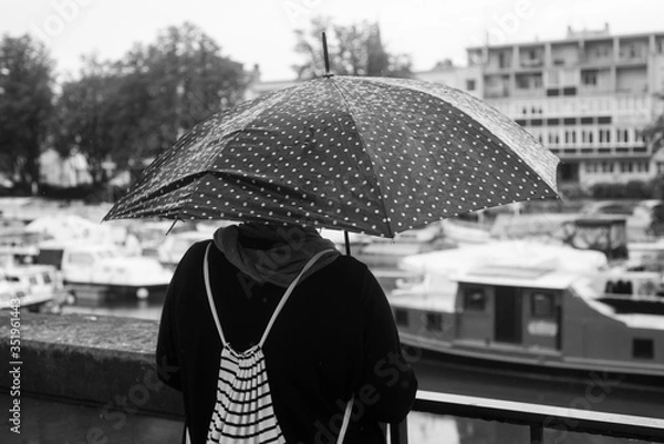 Obraz Portrait of woman standing in the street with black umbrella on back view