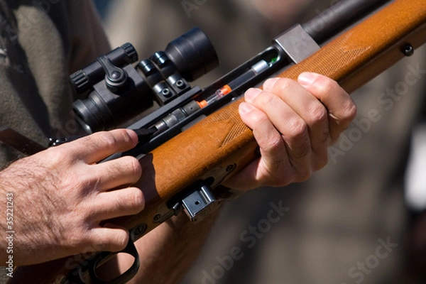 Obraz A man holding a dart gun