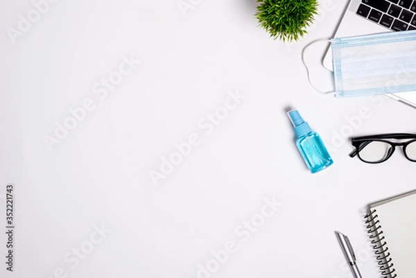 Obraz The equipment to protect COVID-19, blue mask and hand cleaner gel for preparing to work from home Isolated on white background concept.