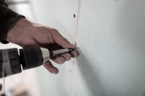 Obraz Anschrauben einer Rigips Platte an eine Wand