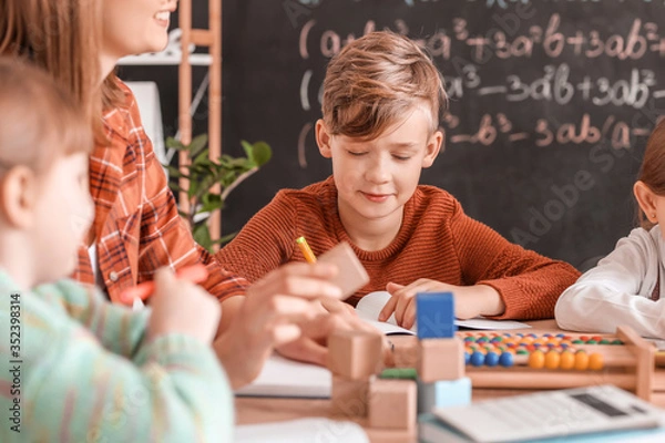 Fototapeta Children with math teacher during lesson in classroom