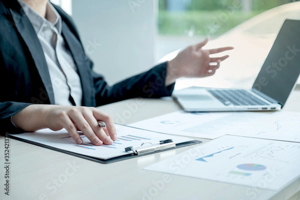 Fototapeta business man is sitting at a desk and calculating financial graph that show results