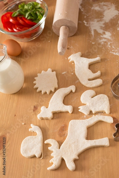 Fototapeta Curly dough cookies are on the table. Glass bottle with milk and handmade cookies.