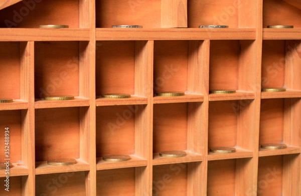 Obraz Compartimentos de madera con monedas.