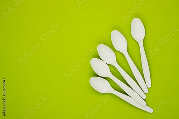Obraz biodegradable spoons on a green background, top view, space for text. caring for nature. the rejection of the plastic