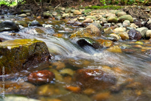 Obraz motion blur of water stream on rocks