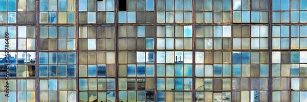 Fototapeta Grunge background of old shop windows of an inactive factory room, traces of aging glass, cracks. Reflections of the blue sky. Aspect ratio 3 to 1.