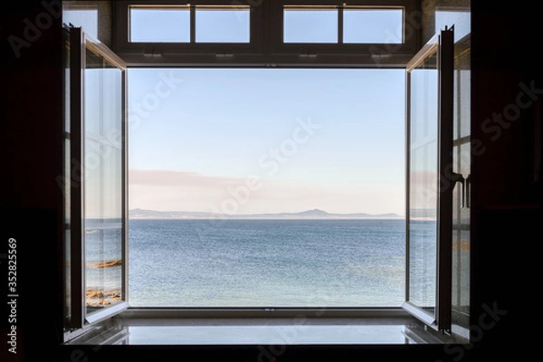 Fototapeta view from a dark room to the sea through an open window