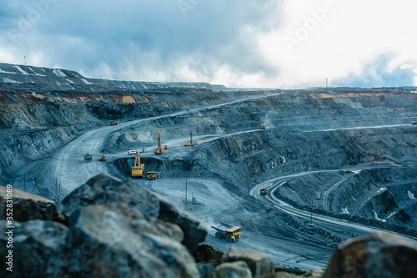 Fototapeta Work of trucks and the excavator in an open pit