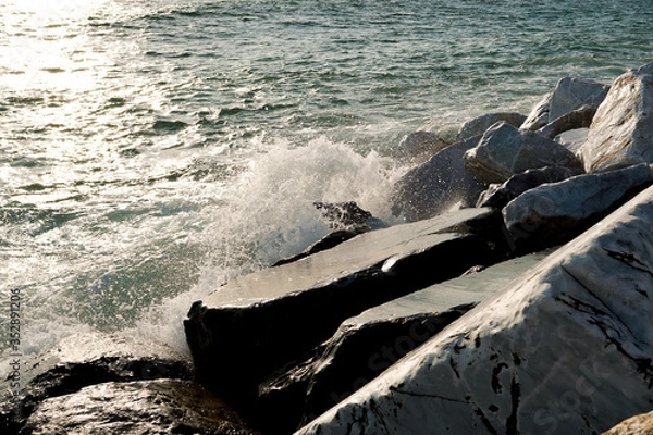Obraz Waves crashing against rocks. Close up. Sunset.