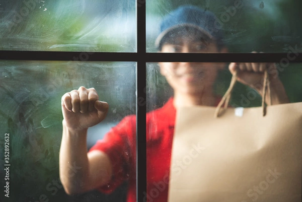 Obraz Diverse bags of paper containers for takeaway fast food, Delivery woman in uniform is caring for one of clients, new normal lifestyle for the social distancing and stay at home