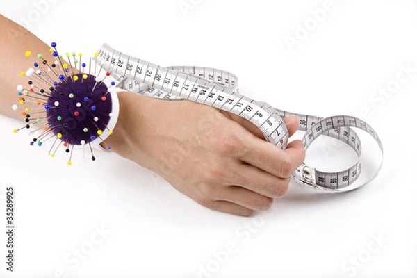 Fototapeta Hand with pincushion and measuring tape