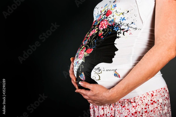 Obraz Belly pregnant woman on a black background
