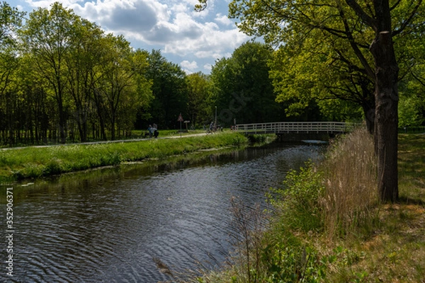 Obraz Country scene of small village bridge across river.