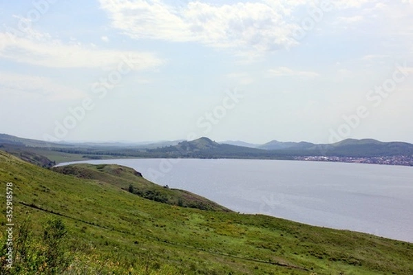 Fototapeta Great panoramic view. A clean mountain lake in the midst of majestic mountains in a haze