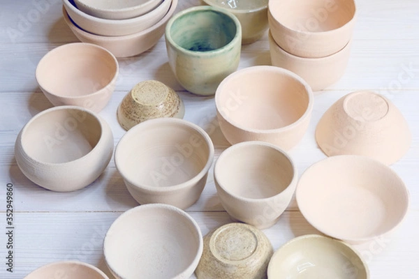Obraz Modern pottery. Decorative ceramic, clay plate. Handmade light pottery.  Set of ceramic, bowls, cup with background.