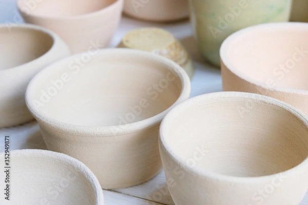 Obraz Modern pottery. Decorative ceramic, clay plate. Handmade light pottery.  Set of ceramic, bowls, cup with background.