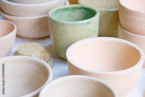Obraz Modern pottery. Decorative ceramic, clay plate. Handmade light pottery.  Set of ceramic, bowls, cup with background.