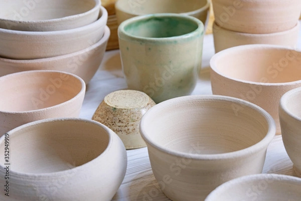 Obraz Modern pottery. Decorative ceramic, clay plate. Handmade light pottery.  Set of ceramic, bowls, cup with background.