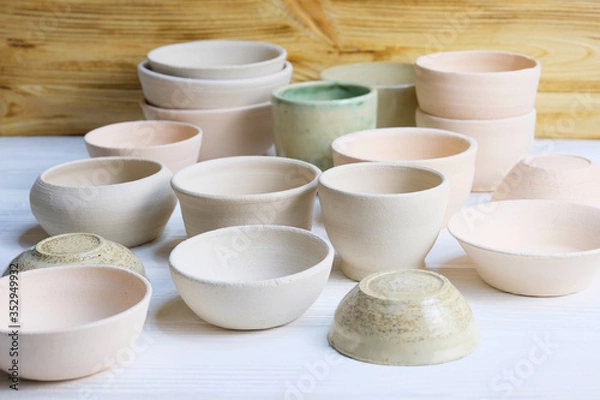Obraz Modern pottery. Decorative ceramic, clay plate. Handmade light pottery.  Set of ceramic, bowls, cup with background.
