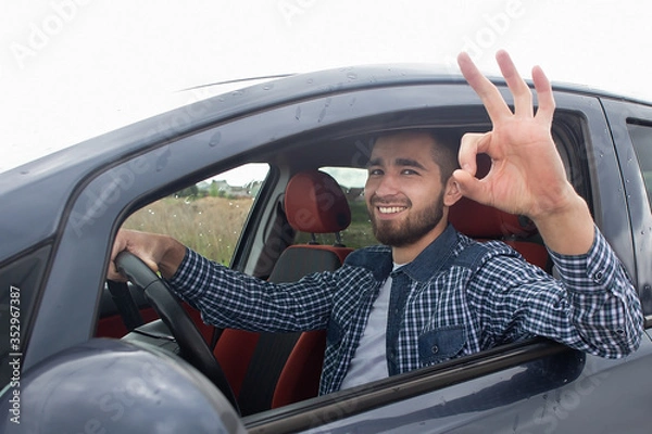 Fototapeta Gestures in a beautiful man's car