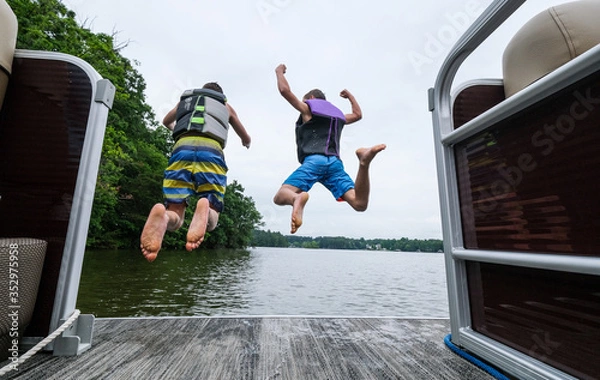 Obraz young men jumping into the lake