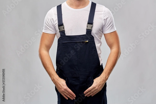 Fototapeta repair, construction and building - close up of male painter or builder in overall over grey background
