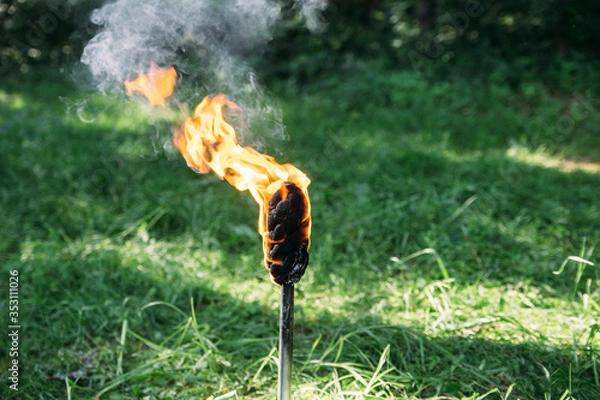 Fototapeta the torch burns with a yellow flame