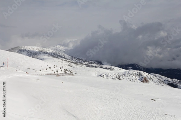 Fototapeta Mountain road with snow on the side and side of it. After passing the snow plow machine.