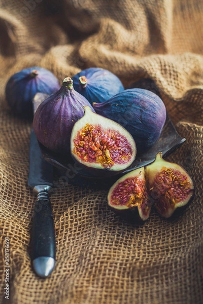 Fototapeta Juicy figs in a rustic style on natural canvas.
