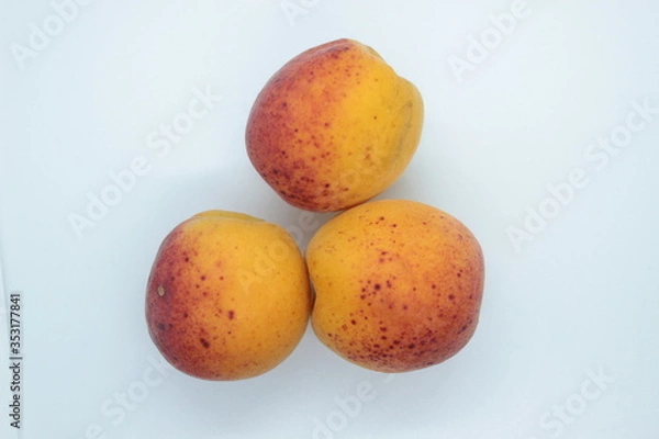 Fototapeta Ripe beautiful apricots are located on a white background
