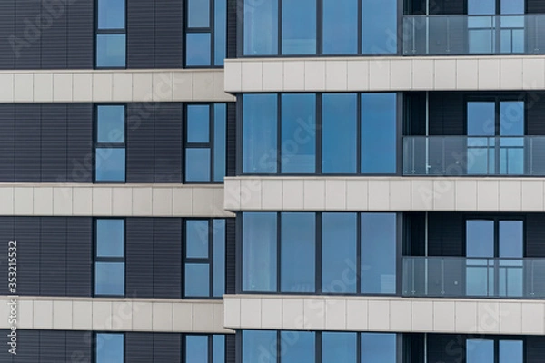 Fototapeta part of the facade of a modern residential building. Modern architecture made of glass and concrete.