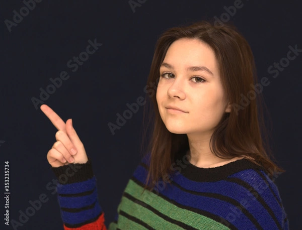 Fototapeta Portrait of a creative young girl looking up while thinking of a new idea or business project against beige background for copy space