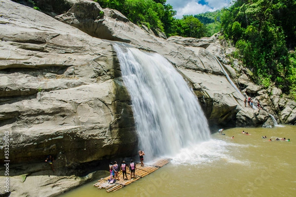 Fototapeta Tourist taking selfies at a floating bamboo boat at the foot of the Tangadan Fall located at La Union Pangasinan Philippines