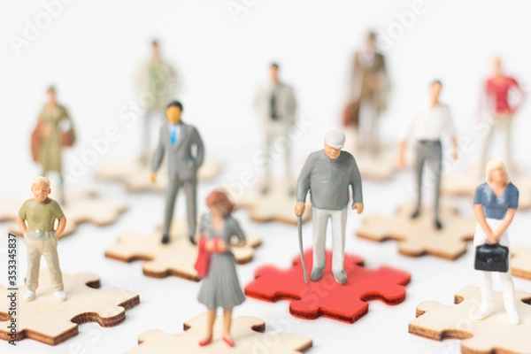 Fototapeta Miniature figures, Infected old person COVID-19 or coronavirus standing on red puzzles and other people standing on puzzles demonstrating the concept of social distancing to protect COVID-19 concept